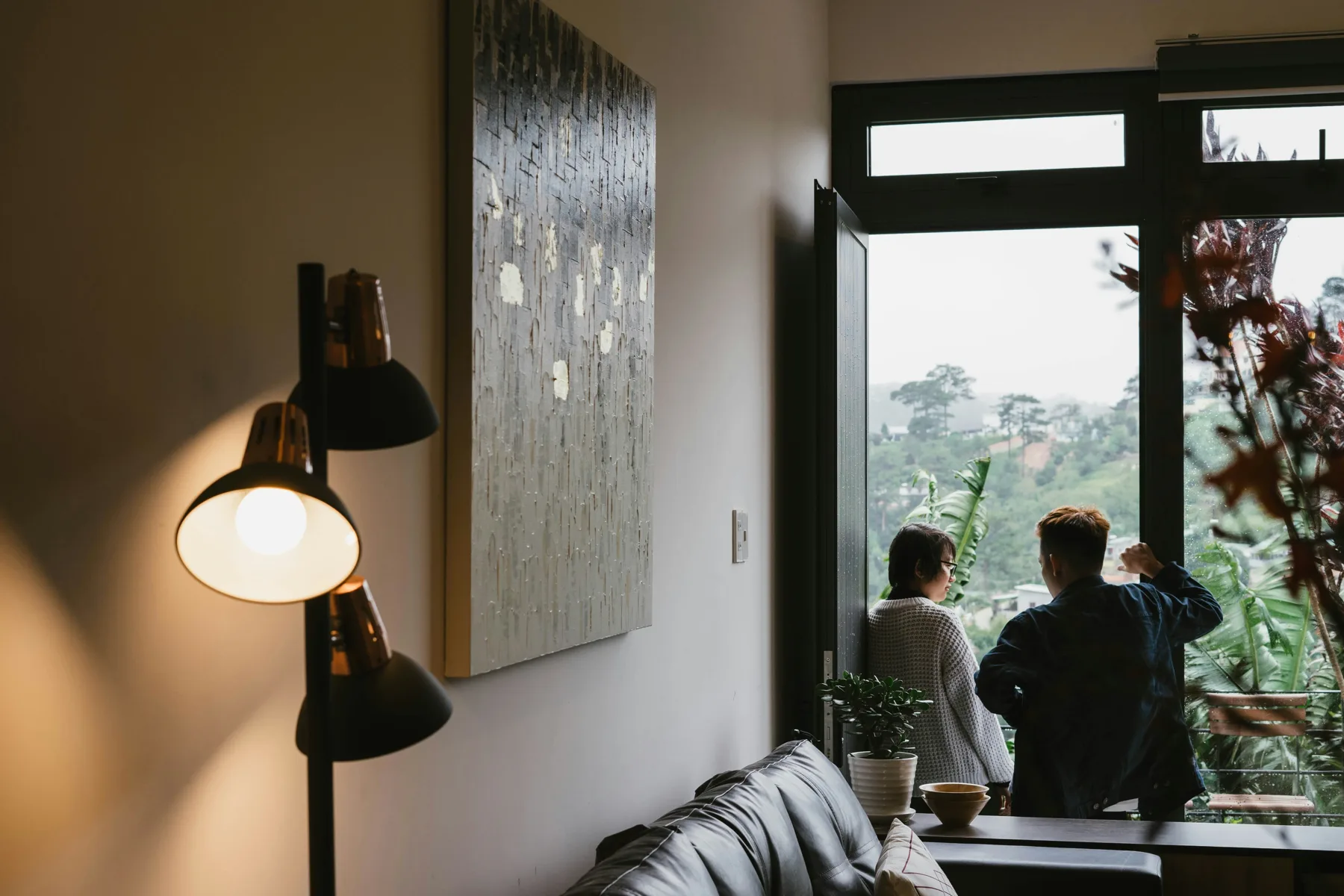 A couple looking out from the window of a home during a viewing